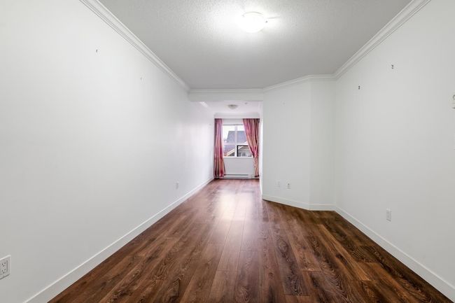 Spare room with crown molding, dark wood-style floors, and a textured ceiling | Image 13