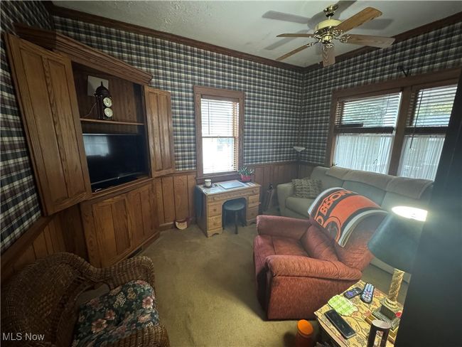 Living area featuring ornamental molding, wallpapered walls, wainscoting, and light colored carpet | Image 8