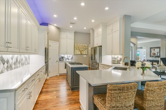 Kitchen with gas cooktop, high quality fridge, recessed lighting, light wood-style floors, and tasteful backsplash | Image 12