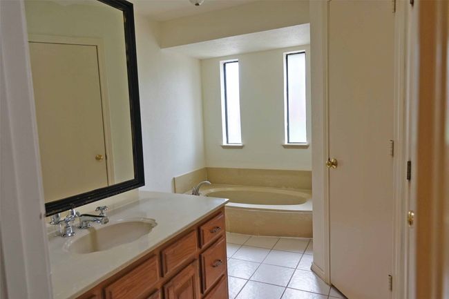Full bathroom with a garden tub, vanity, and tile patterned flooring | Image 13