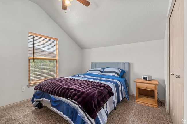 Carpeted bedroom featuring lofted ceiling, ceiling fan, and baseboards | Image 18