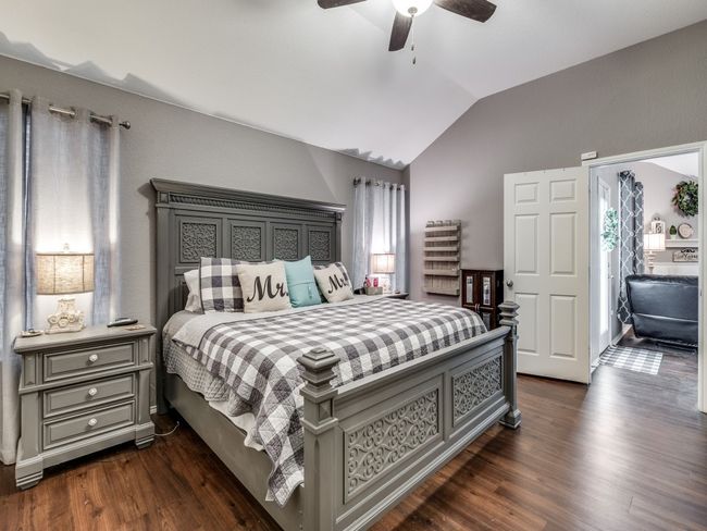 Bedroom featuring lofted ceiling, dark wood finished floors, multiple windows, and ceiling fan | Image 18