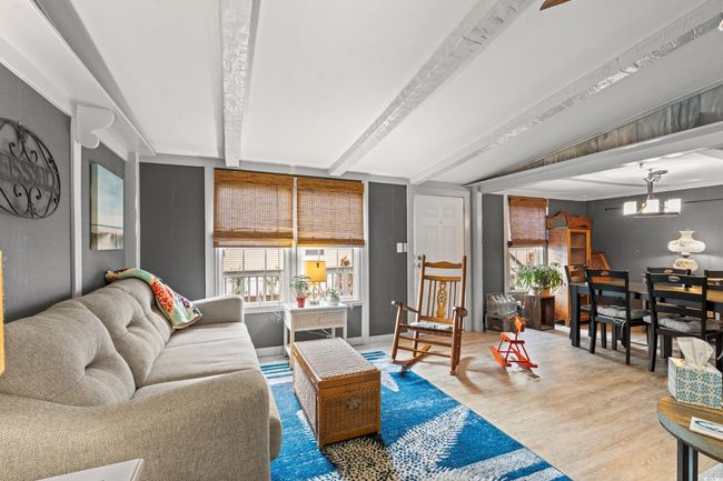 Living room with lofted ceiling with beams, light hardwood / wood-style floors, and an inviting chandelier | Image 6