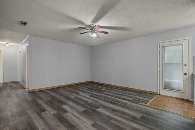 Spare room with a ceiling fan, wood finished floors, a textured ceiling, and ornamental molding | Image 16