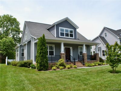 Craftsman house with a front yard and a porch. Black iron side gate to back yard. | Image 1