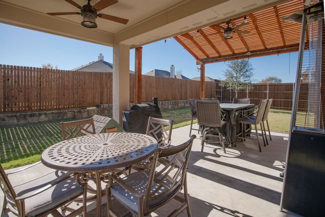 Fenced backyard featuring outdoor dining area, ceiling fan, and a patio | Image 33