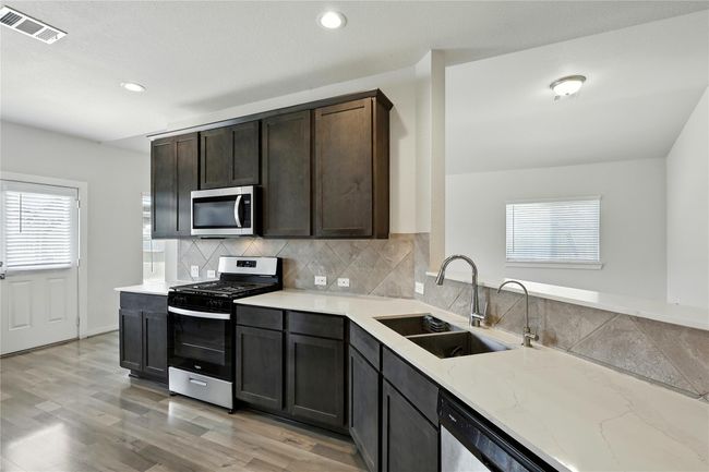 Nice kitchen area with gas range, double sinks, and reverse osmosis under sink system. | Image 18