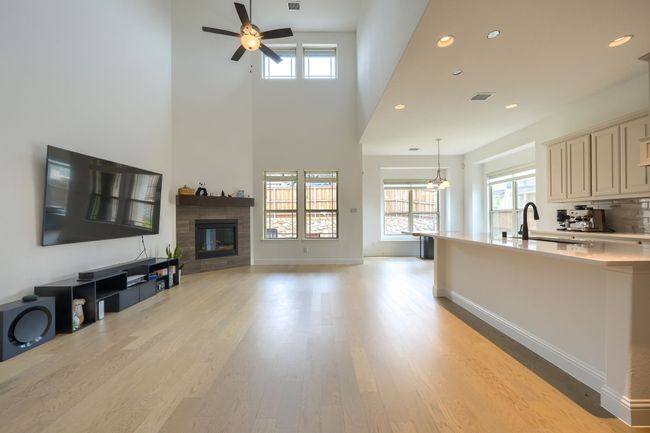 Living room featuring recessed lighting, visible vents, a fireplace, light wood-style flooring, and ceiling fan | Image 6