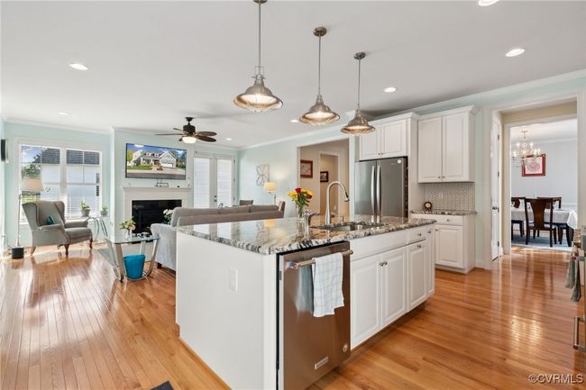 Pre-finished hardwood flooring throughout almost all of the first floor. Large island offering additional prep space and seating. Peak-a-boo view of dining room just past the butler's pantry. | Image 5