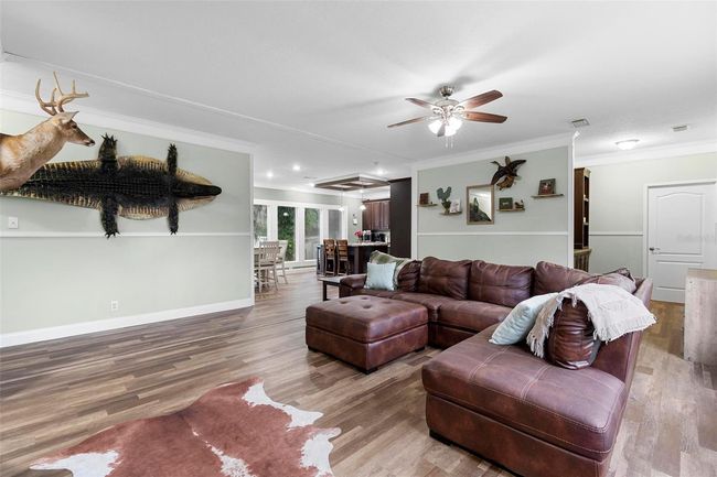 Family room looking into kitchen, front entrance built-ins and primary bedroom door | Image 5