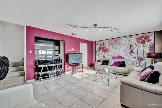 Living area featuring track lighting, tile patterned flooring, stairway, and baseboards | Image 7