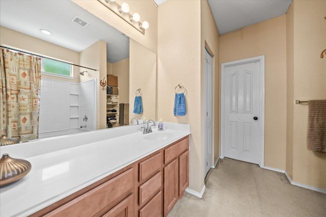 Full bathroom featuring vanity, shower / tub combo, baseboards, and a closet | Image 29