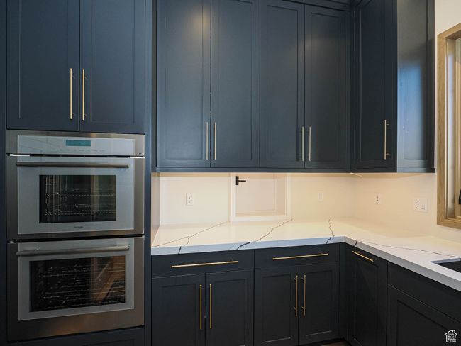 Kitchen with double oven and light stone countertops | Image 41