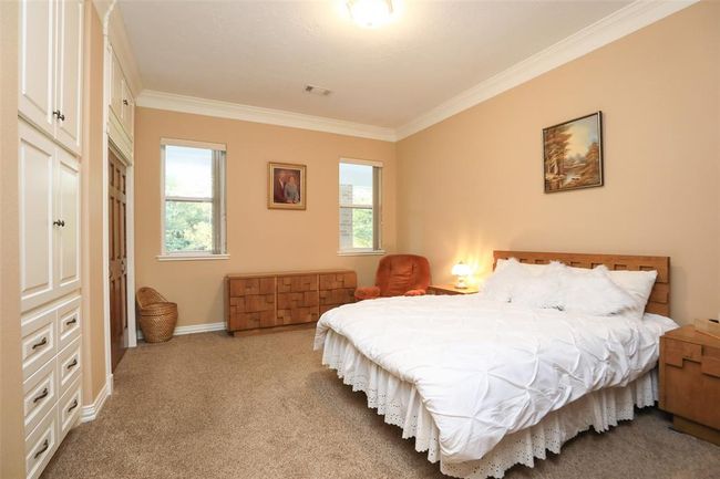 Bedroom features crown molding, wall units, nice closet and generous extra storage cabinets. | Image 27