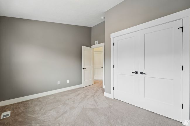 Unfurnished bedroom featuring a closet, visible vents, light colored carpet, and baseboards | Image 38