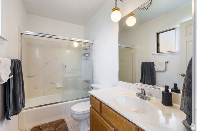 Full bathroom with tile patterned flooring, enclosed tub / shower combo, vanity, and toilet | Image 14