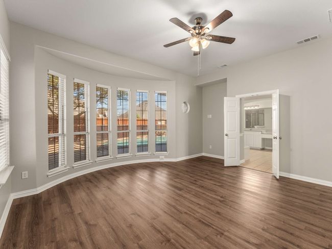 Unfurnished room with visible vents, baseboards, wood finished floors, and a ceiling fan | Image 7