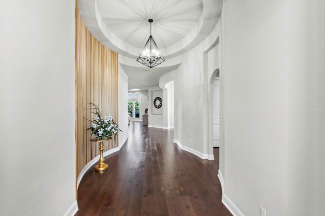 View of the entry featuring hardwood flooring, a chandelier, and arched walkways | Image 4