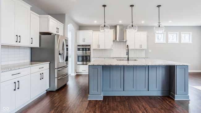 This kitchen is a chef's dream! A huge island with granite counter tops, top of the line stainless appliances and an induction cook-top. | Image 15