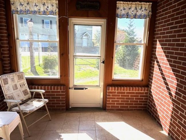 Doorway featuring brick wall and light tile patterned floors | Image 32