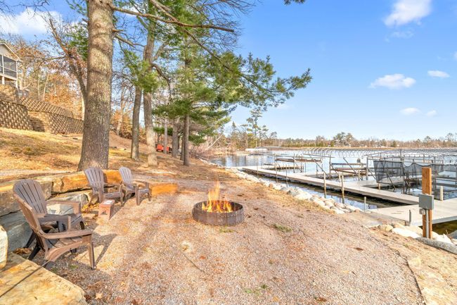 New fire pit and landscaping around fire pit. A landscaped gravel path (for golf carts/UTVs) leads down to the waterfront and fire pit. | Image 56