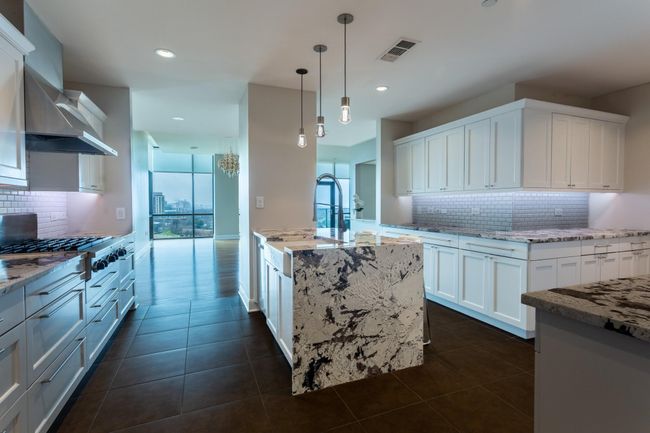 Huge kitchen with waterfall island. | Image 16