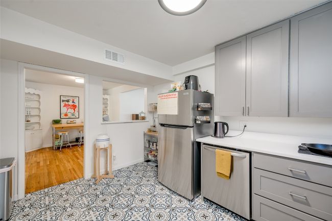 Kitchen with gray cabinets, appliances with stainless steel finishes, light countertops, and baseboards | Image 11