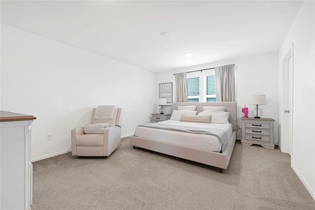 Spacious primary suite offers comfort and privacy with soft natural lighting. | Image 18