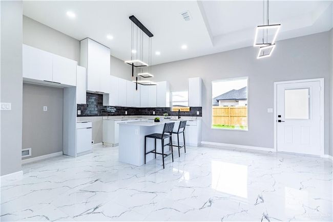 View from living room space looking at kitchen, dining area and back door. | Image 5