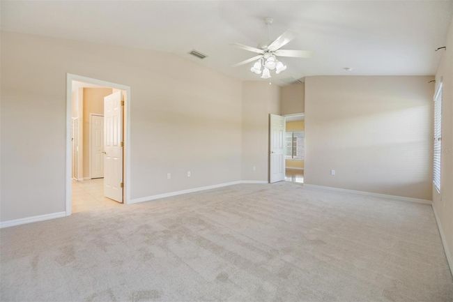 Master with neutral color palette and room for a reading nook | Image 13