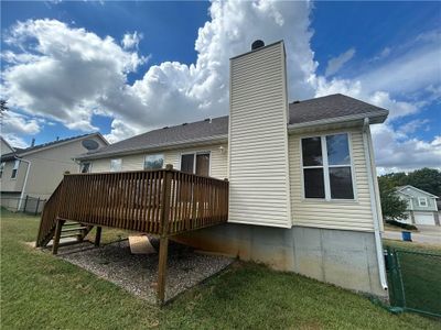 Back of property with a lawn, a wooden deck, and a garage | Image 3