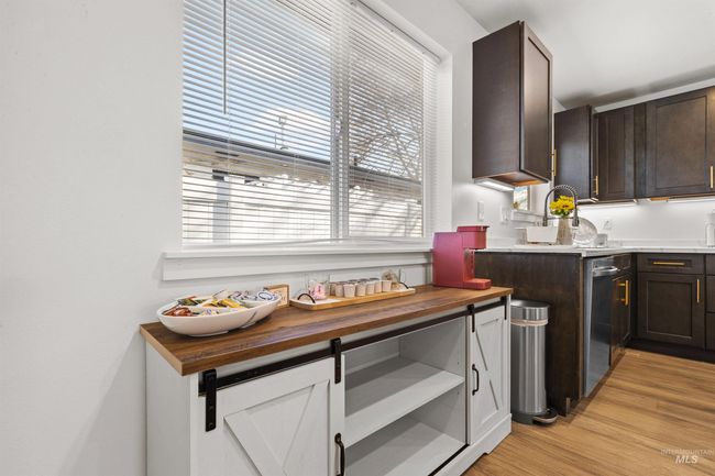 Kitchen with dark brown cabinetry, light wood finished floors, butcher block counters, and dishwasher | Image 14