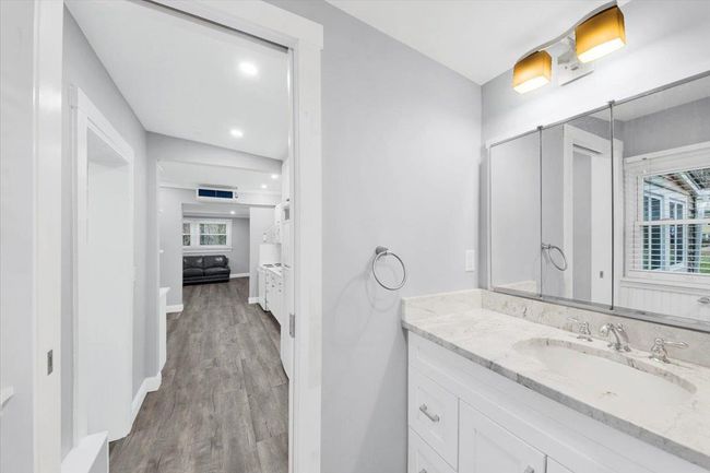 Bathroom with vanity, healthy amount of natural light, wood finished floors, baseboards, and recessed lighting | Image 15