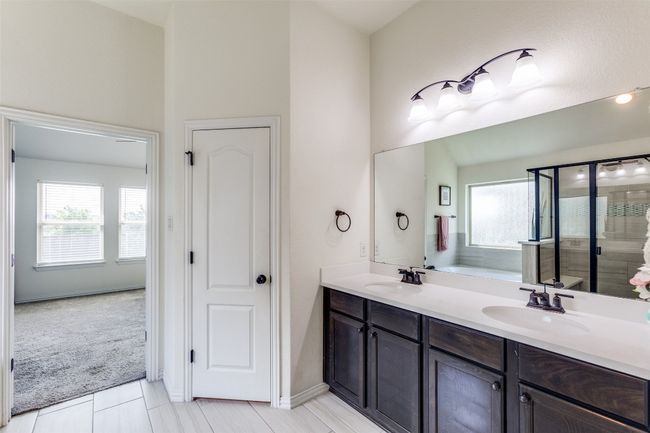Full bathroom with double vanity, a stall shower, a garden tub, and tile patterned floors | Image 17
