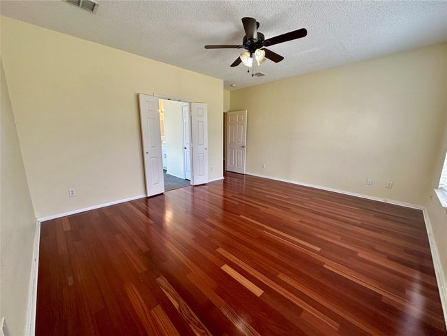 Unfurnished bedroom with wood finished floors, a textured ceiling, and ceiling fan | Image 14
