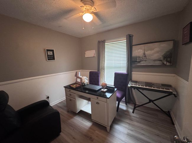 Office space with wood finished floors, a textured ceiling, ceiling fan, and baseboards | Image 5