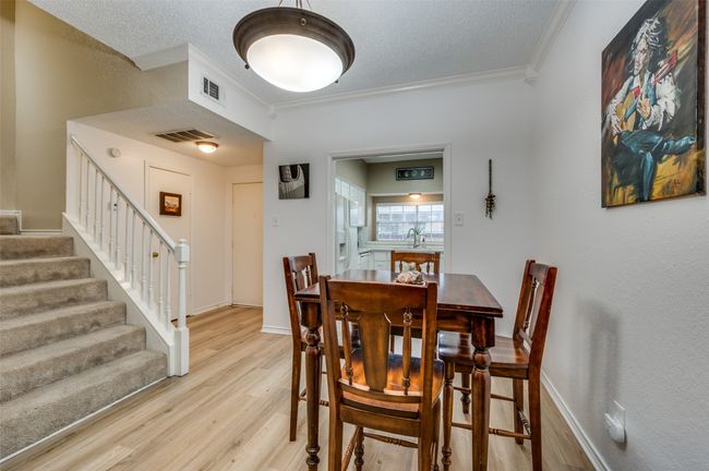 Dining room with sink, crown molding, light hardwood / wood-style flooring, and a textured ceiling | Image 6