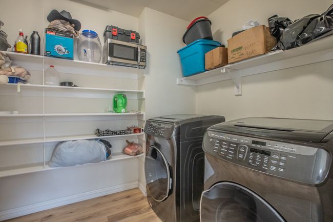 Washroom featuring washing machine and dryer, wood finished floors, and laundry area | Image 8