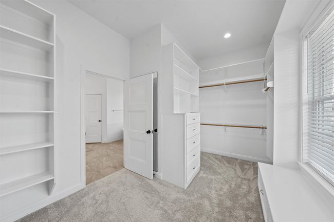 Spacious closet with light carpet and attic access | Image 17