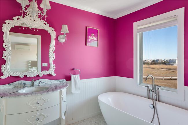 Bathroom featuring a freestanding bath, a wall mounted AC, a healthy amount of sunlight, wainscoting, and vanity | Image 13