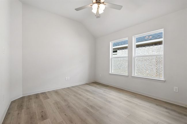 Unfurnished room with ceiling fan, light wood-style flooring, and lofted ceiling | Image 15
