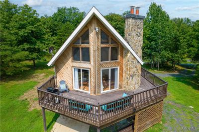 Back of house featuring a wooden deck and a lawn | Image 1