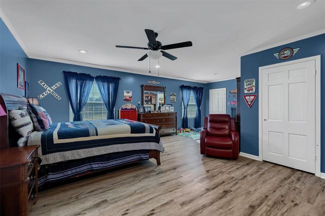 Bedroom with multiple windows, crown molding, wood finished floors, recessed lighting, and baseboards | Image 28