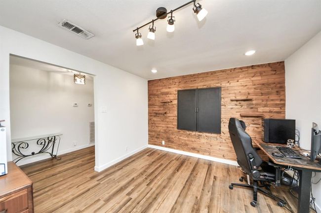 Formal living area or ideal home office, highlighted by a warm wood accent wall that adds character and charm. | Image 20