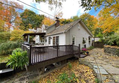 Front/Side View of property featuring a wooden deck & nice stonework | Image 3