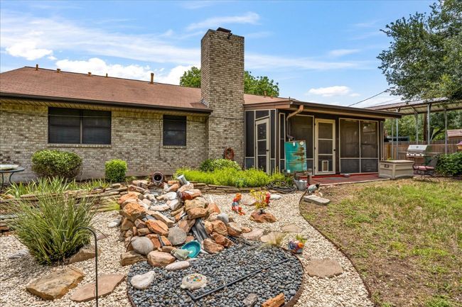 Rear view of property featuring a sunroom, a chimney, brick siding, and roof with shingles | Image 29