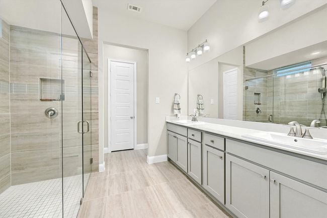 Full bathroom featuring a sink, a shower stall, and visible vents | Image 19