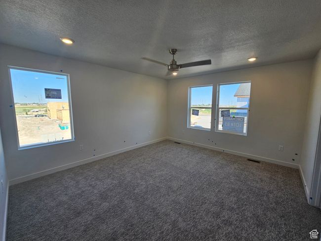 Empty room featuring a textured ceiling, carpet flooring, a ceiling fan, and recessed lighting | Image 16