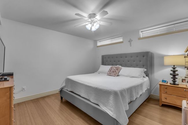 Bedroom featuring wood finished floors, a ceiling fan, and baseboards | Image 26
