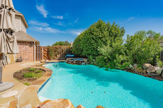 View of pool with a patio area, a fenced backyard, a gate, and a pool with connected hot tub | Image 35